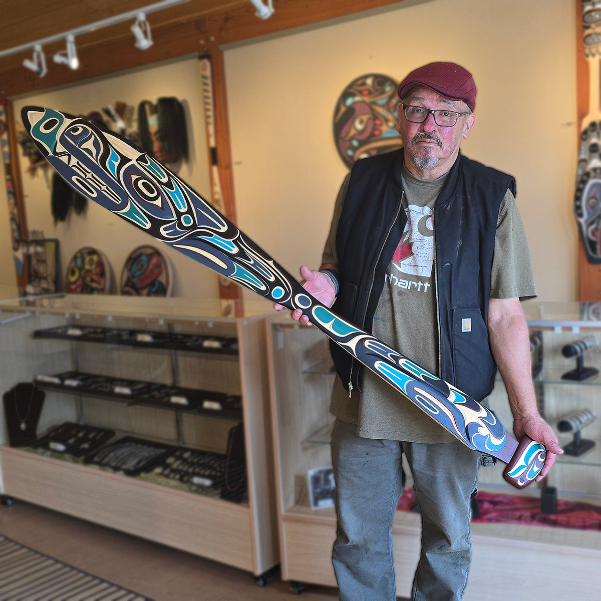 Kwakwaka'wakw artist Tom D. Hunt holding his Wolf Paddle