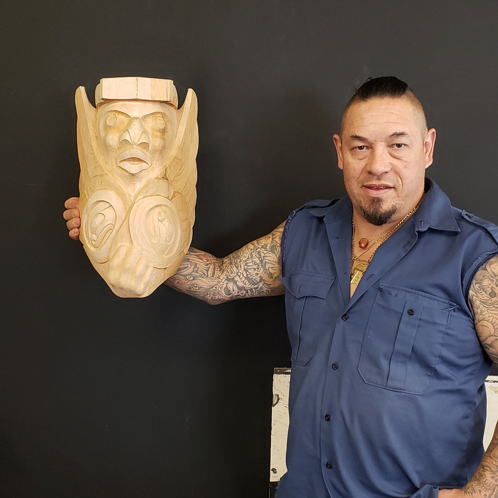 Kwakwaka'wakw artist Junior Henderson holding Carved Medicine Man Mask in progress