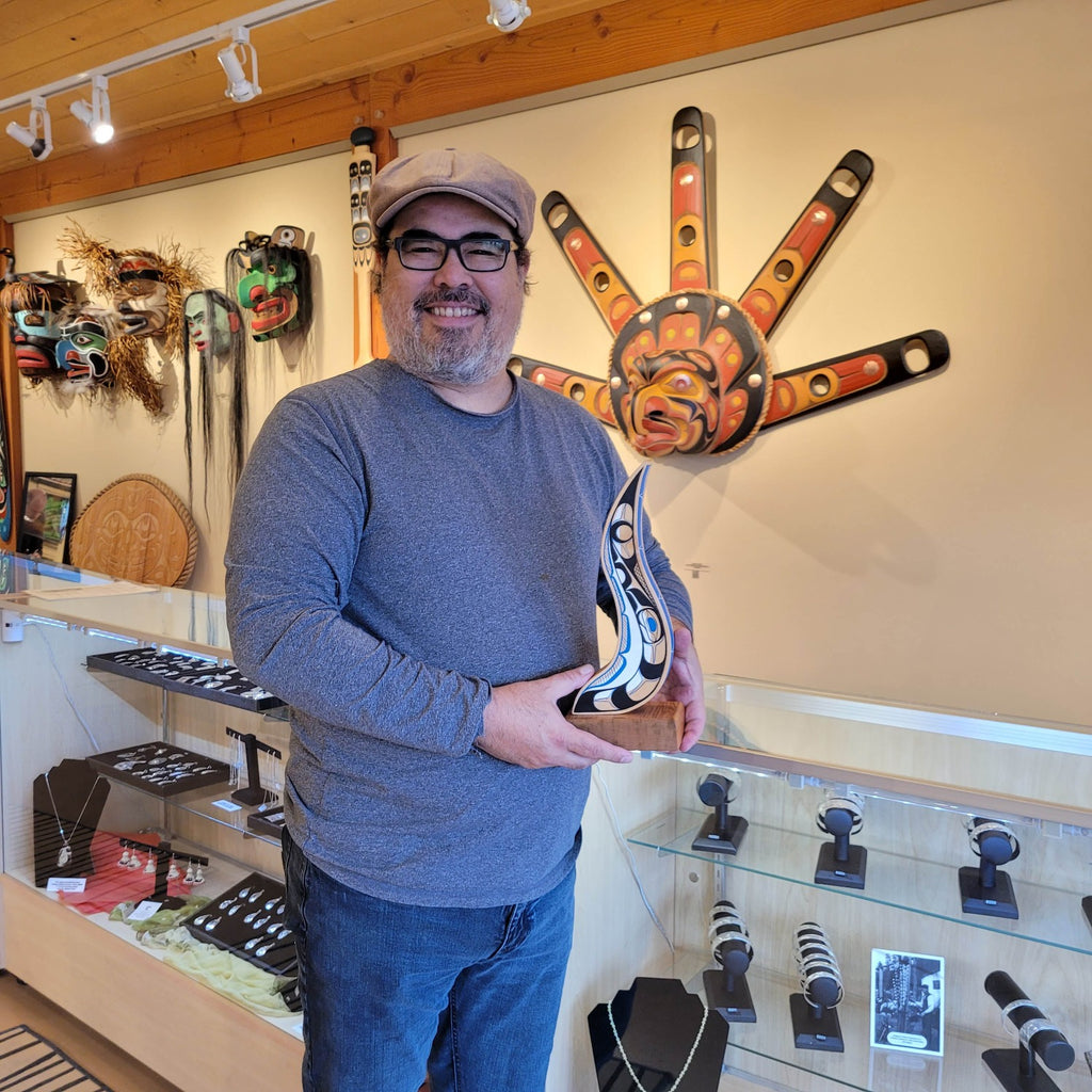 Kwakwaka'wakw artist Rod Smith holding First Nations Abstract carving