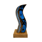 Decorative wooden sculpture with blue and black patterns on a white background