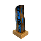 Wooden object with blue and black design on a white background