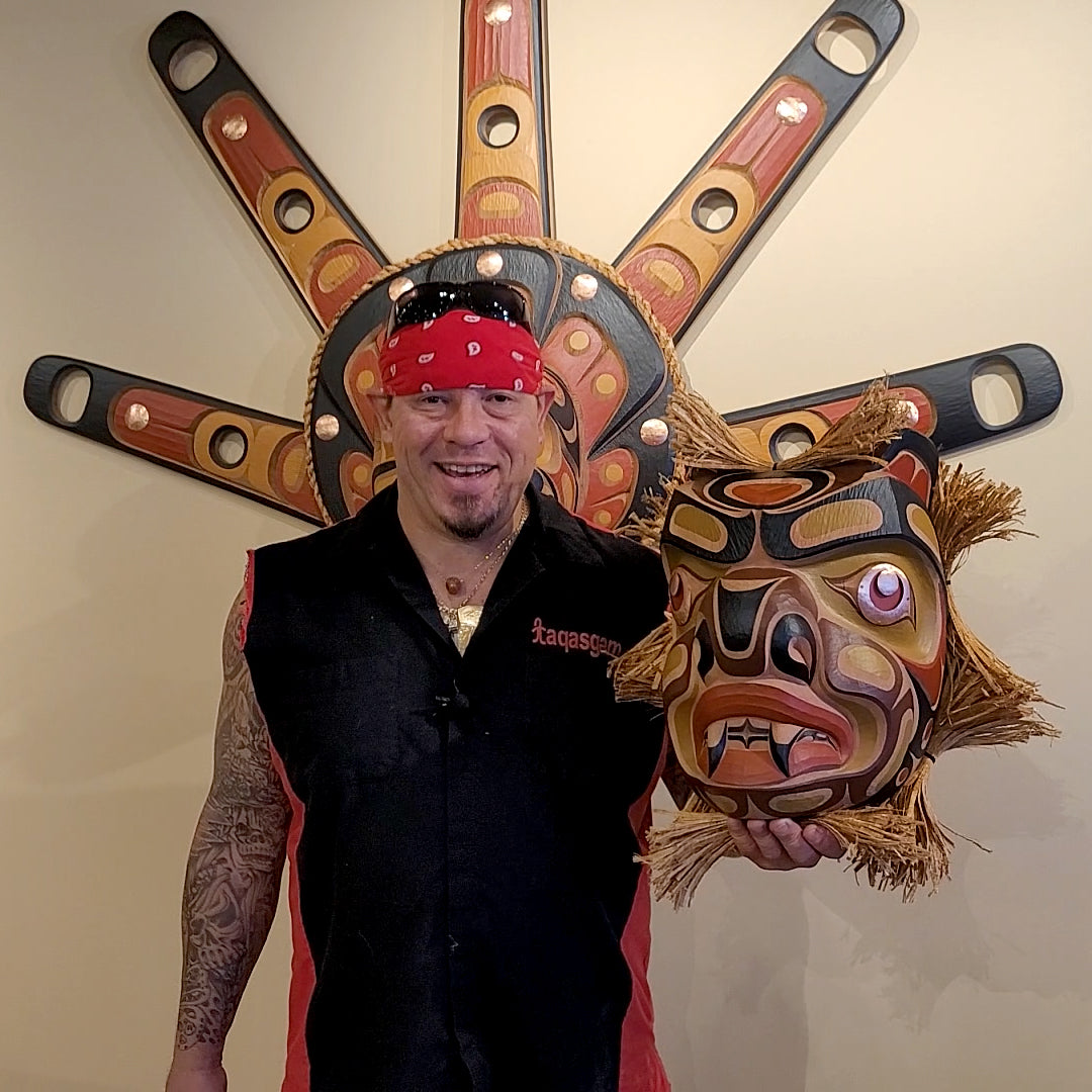 Kwakwaka'wakw artist Junior Henderson holding Carved Bear Mask