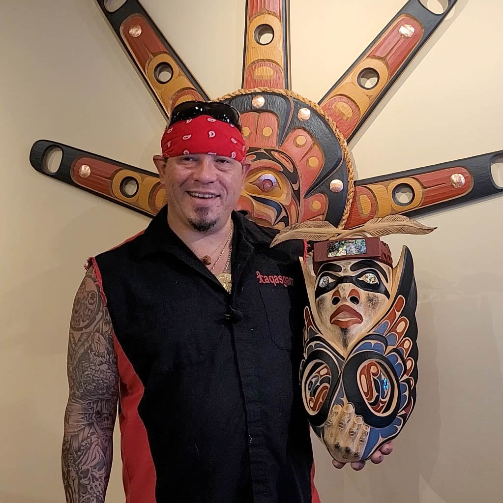 Kwakwaka'wakw artist Junior Henderson holding Carved Medicine Man Mask