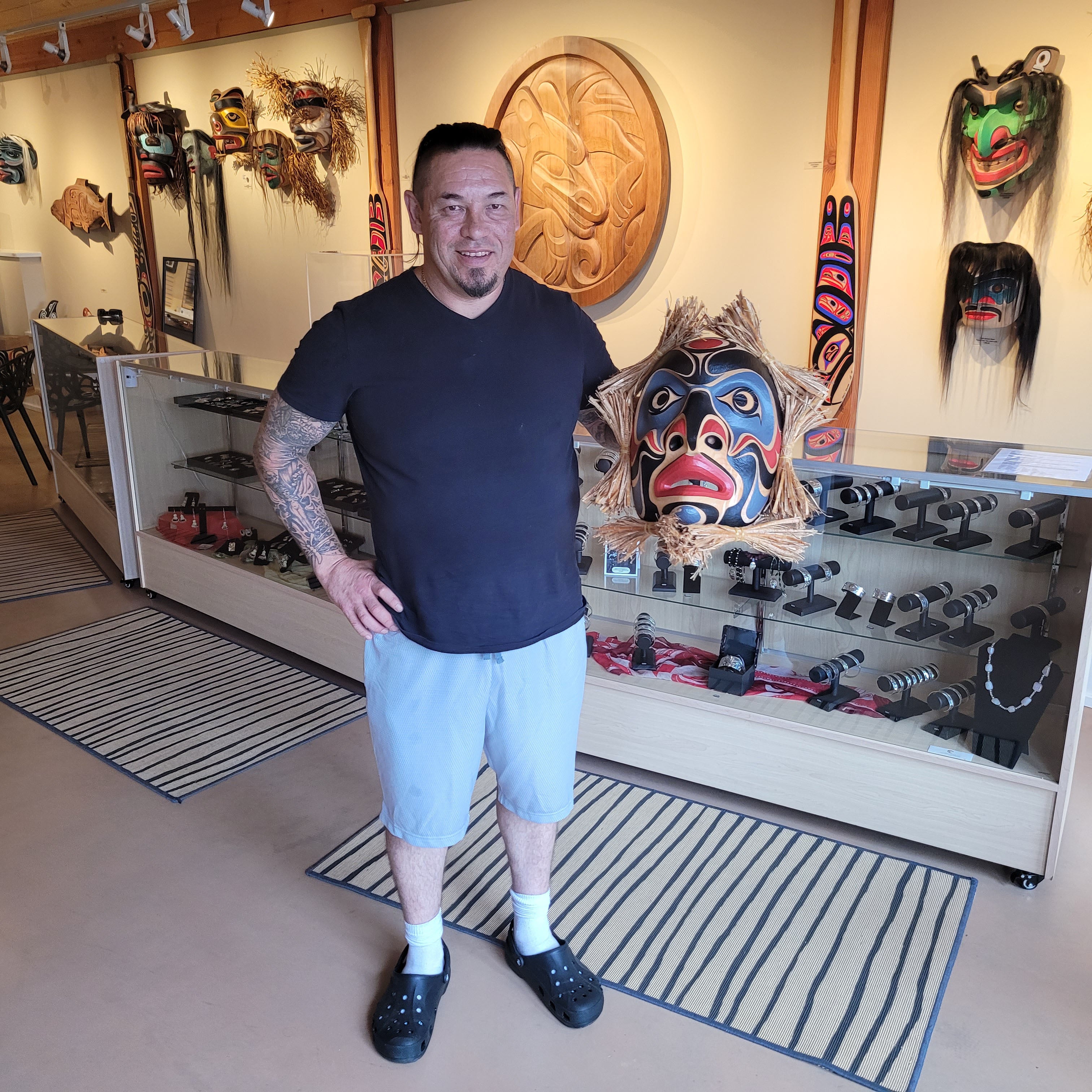 Kwakwaka'wakw artist Junior Henderson holding First Nations Portrait Mask