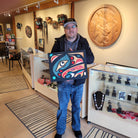 Kwakiutl artist Trevor Hunt holding Rectangular Sandblasted Raven Panel